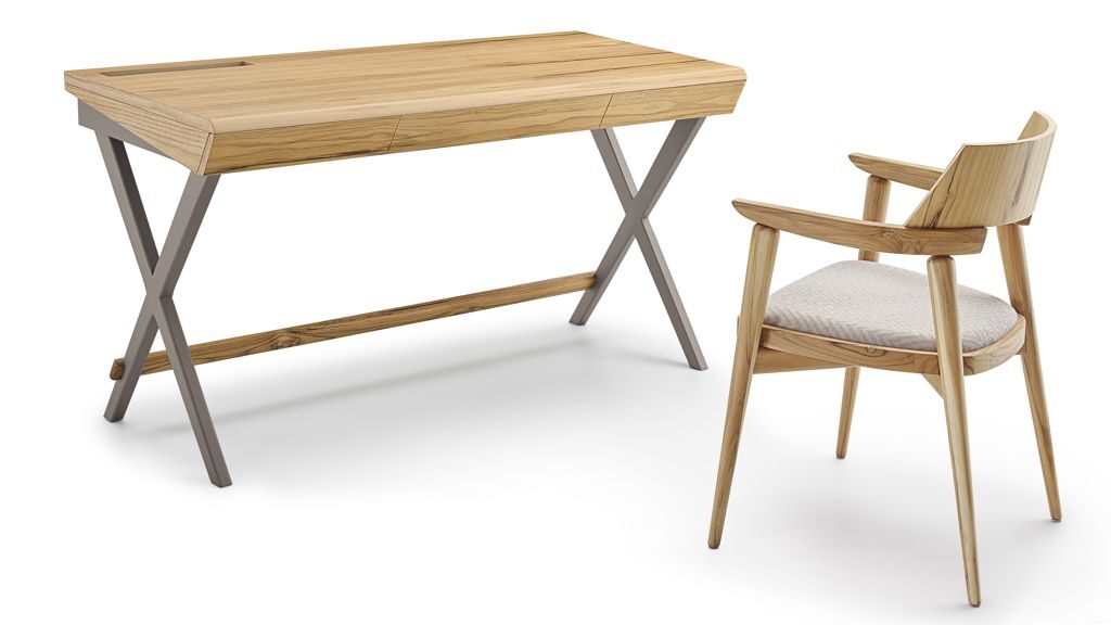 Na imagem, a escrivaninha possui madeira maciça e metal em sua composição. À sua frente, também em madeira e com espuma de alta qualidade, é possível visualizar uma cadeira. 