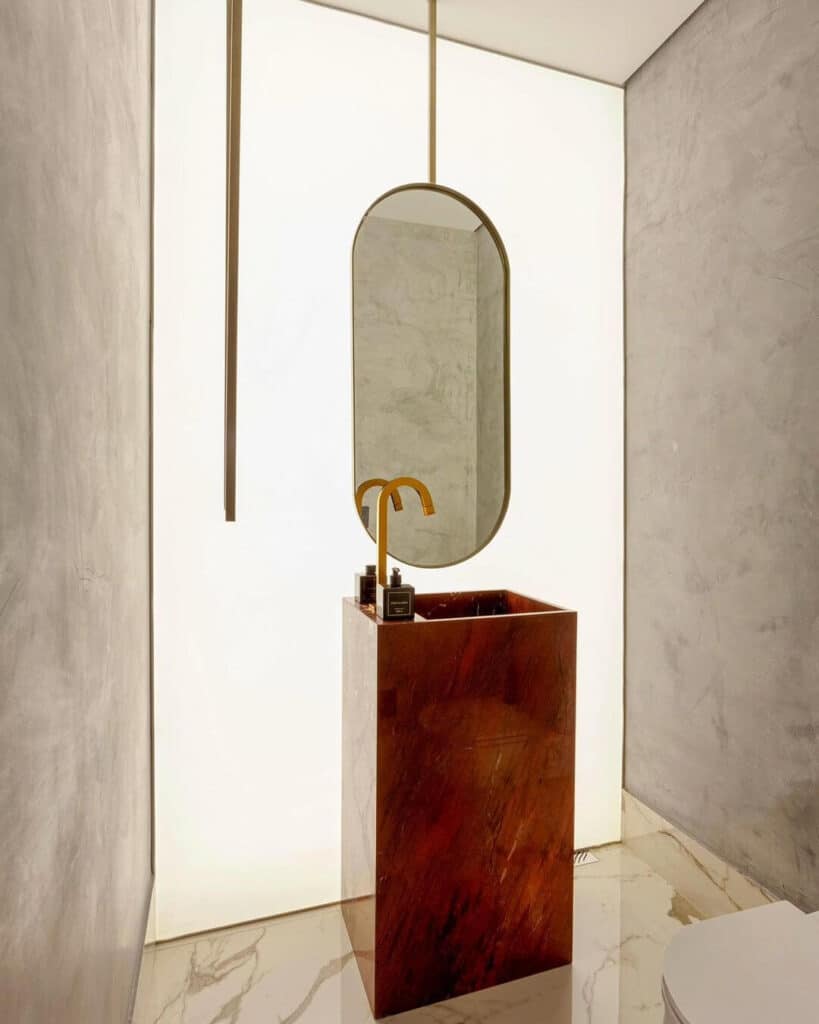 Banheiro com lona tensionada iluminada e mármore exótico do Escritório Merenciano & Usso. Projeto da arquiteta Isabela Junqueira, de Maringá.
