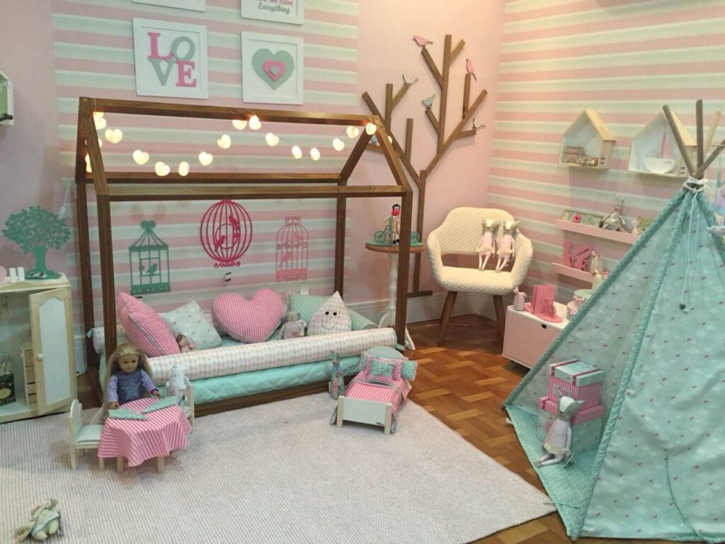 Nesta imagem, o quarto é destinado para as meninas. Em tons claros de rosa, o quarto conta com uma cama no chão e detalhes charmosos. 
